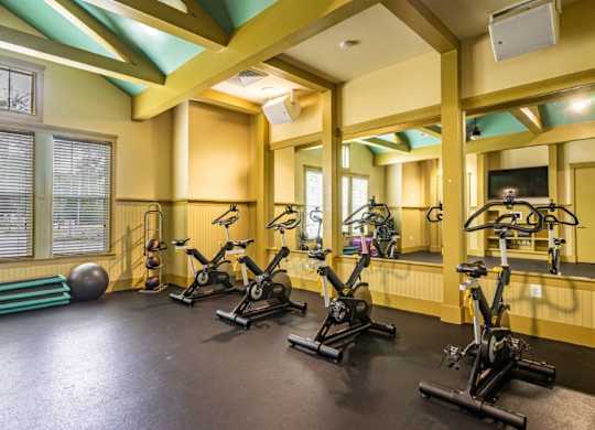 Resident fitness center with a row of exercise bikes and mirrors on the wall at Bridges at Crosstown in Tampa, FL