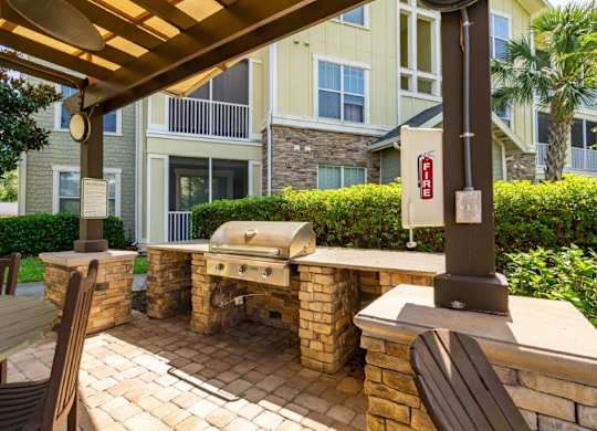 A patio with a grill and chairs at Bridges at Crosstown in Tampa, FL