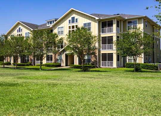 Apartment building exterior with a green lawn in front at Bridges at Crosstown in Tampa, FL