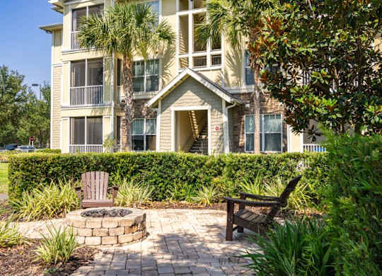 Apartment building with a balcony and a fire pit in front at Bridges at Crosstown in Tampa, FL