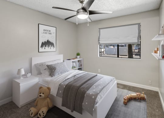 a bedroom with a ceiling fan and a window with a blind