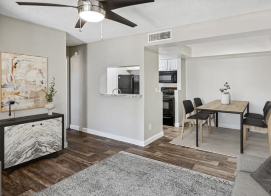 a living and dining area with a ceiling fan and hardwood floors