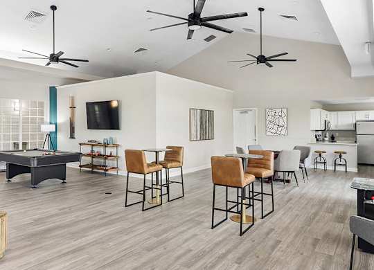 Community Clubhouse with Lounge Furniture, Kitchenette and Game Tables at Mirage on Kernan Apartments located in Jacksonville, FL.