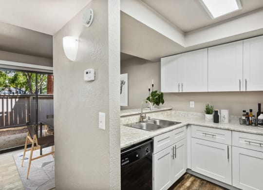 a kitchen with white cabinets and a black dishwasher