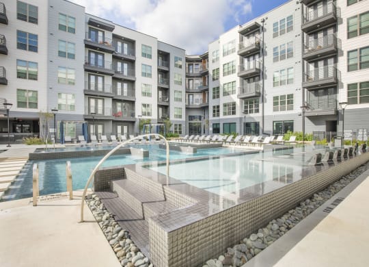 a swimming pool with an apartment building in the background