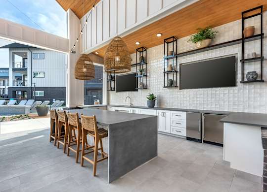 A modern kitchen with a bar area and a balcony.