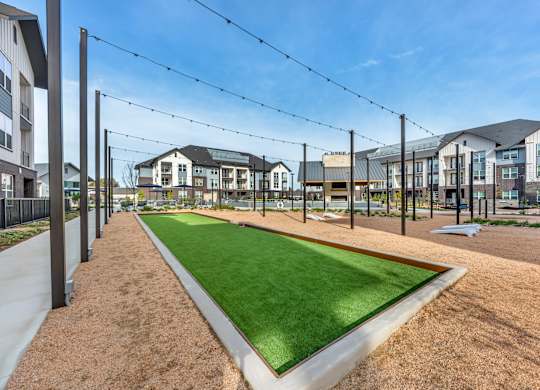 A grassy area in front of apartment buildings with a clear blue sky.