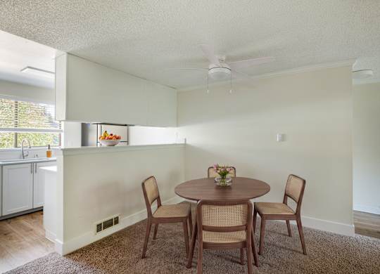 A dining room with a round table and chairs.