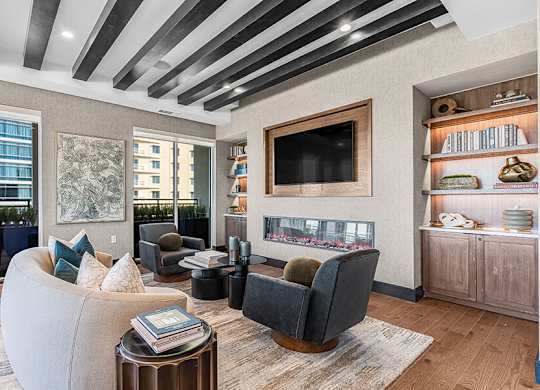 Community Clubhouse with Lounge Furniture, TV and Fireplace at Ovation at Galatyn Park Apartments located in Richardson, TX.