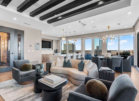Community Clubhouse with Lounge Furniture and Kitchenette Area at Ovation at Galatyn Park Apartments located in Richardson, TX.