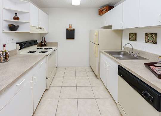 A kitchen with white cabinets and a black stove top.