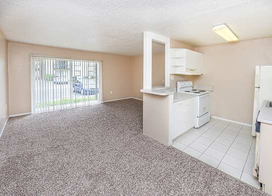 A kitchen area with a white fridge, stove, and microwave.