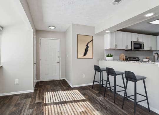 Open kitchen and living room with a breakfast bar and stools