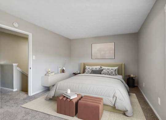 Model apartment bedroom with a large bed and a carpeted floor