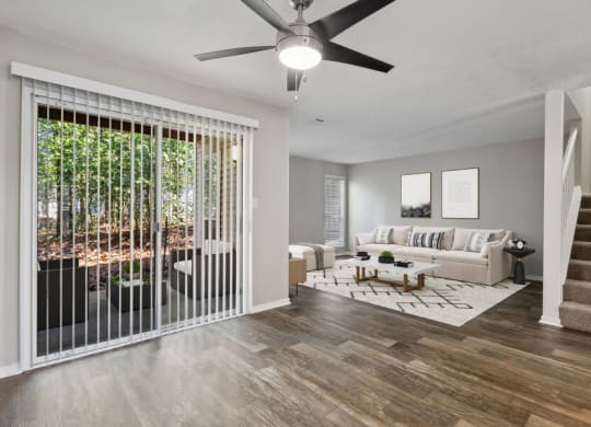 Model apartment living room with a couch and a ceiling fan
