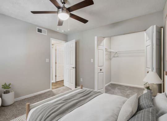 Model apartment bedroom with a bed and a ceiling fan