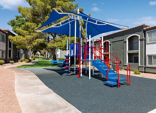 Community Playground with a Slide and Blue Canopy at Loma Vista Apartments in Las Vegas, NV.