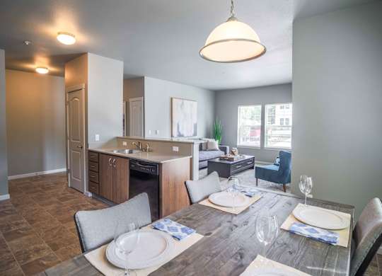 A modern kitchen with a dining table set for two.