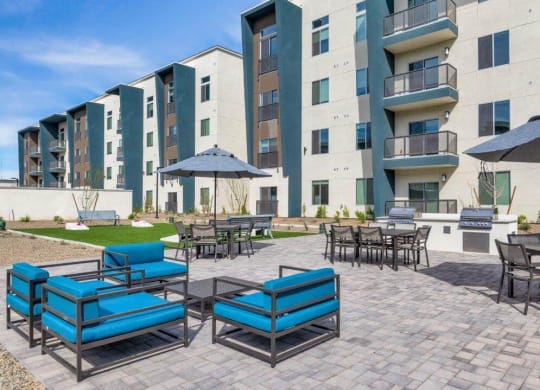 Patio lounge area with BBQ grills at Glen 91 Apartments in Glendale, AZ