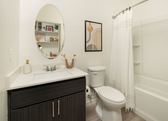 a bathroom with a white sink and toilet next to a white bathtub with a shower curtain