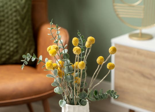 a vase with yellow flowers on a table