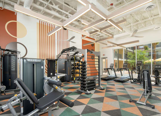 a view of the fitness center with a variety of exercise equipment