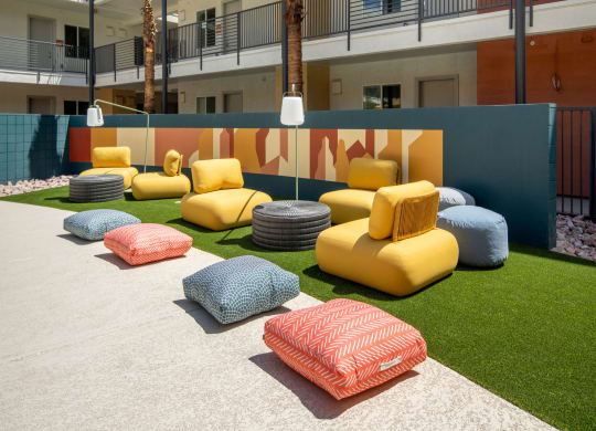 a seating area with couches and pillows in front of a building