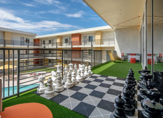 a large chess board on a balcony with a blue sky in the background