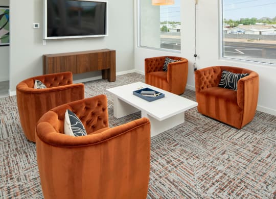 a living room with orange chairs and a white coffee table