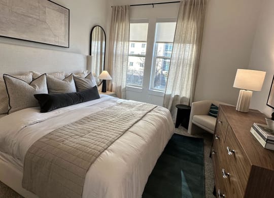 a bedroom with a bed and a dresser and a window