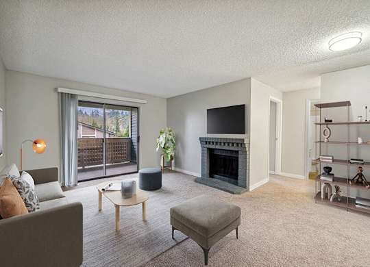 Model Living Room with Carpet, Fireplace and Patio Accessibility at Grammercy Apartments located in Renton, WA.