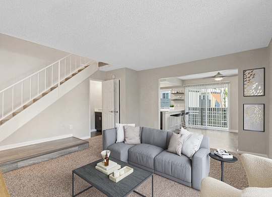Model Living Room with Carpet and View of Kitchen at Horizon Apartments located in Santa Ana, CA.