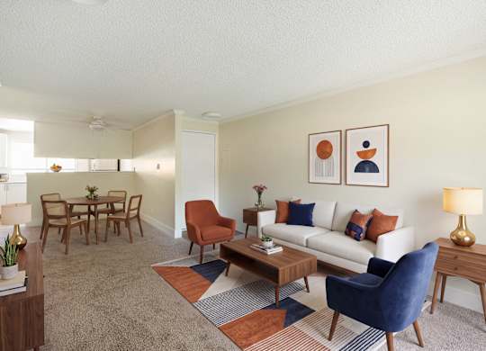 A living room with a white couch, a blue chair, and a wooden coffee table.