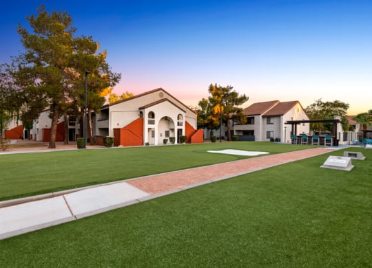 a green lawn in front of a building with a playground at Lore South Mountain, Phoenix, Arizona