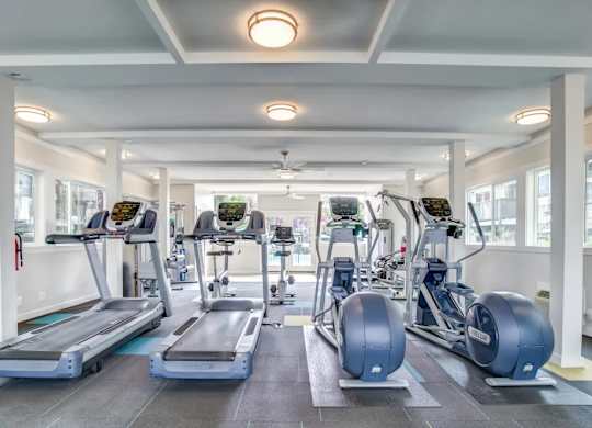 A gym with treadmills, elliptical machines, and other exercise equipment.