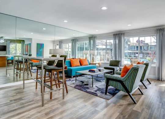 A modern living room with a glass wall and a wooden floor.