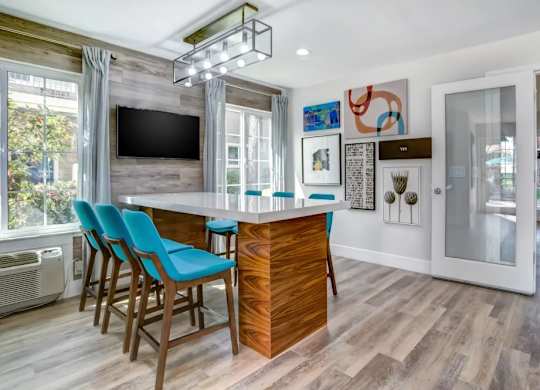 A modern kitchen with a bar area and a television.