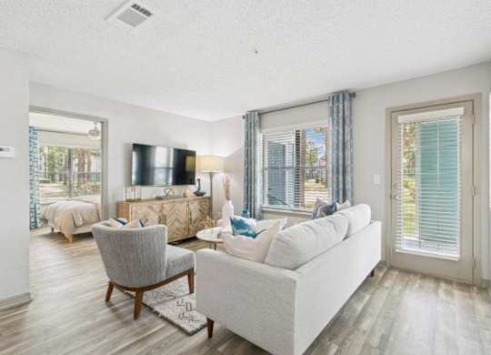 A living room with a grey couch, a chair, and a television.