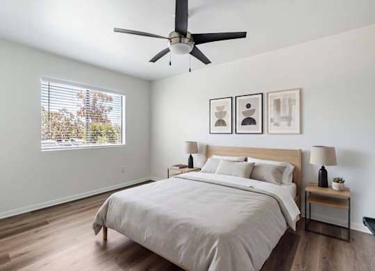 A bedroom with a large bed and a ceiling fan.