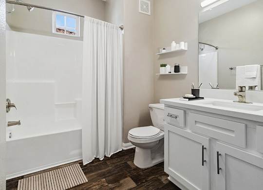 A white bathroom with a toilet, sink, and bathtub.