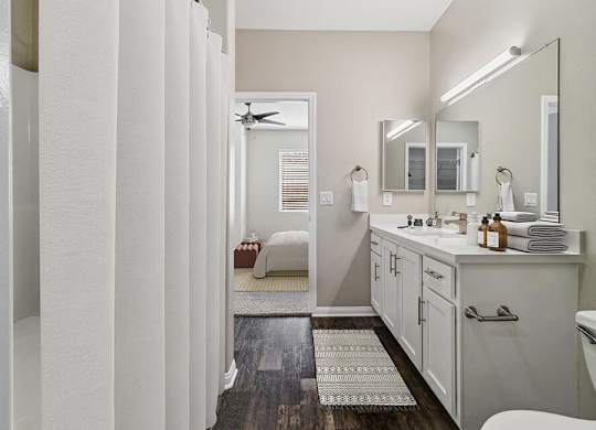 A bathroom with a white vanity and a white toilet.