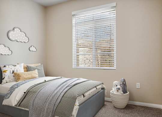 A bedroom with a bed, pillows, a window with blinds, and cloud wall decals.