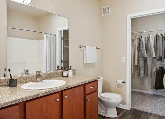 A bathroom with a white toilet and a mirror above the sink.