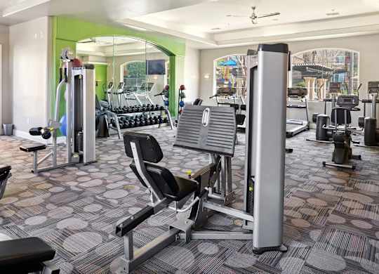 A gym with a variety of equipment including a weight machine and a bench press.