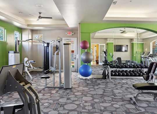 A gym with a variety of equipment including weights and a bench.