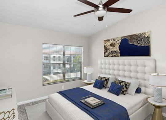 A bedroom with a large bed and a ceiling fan.