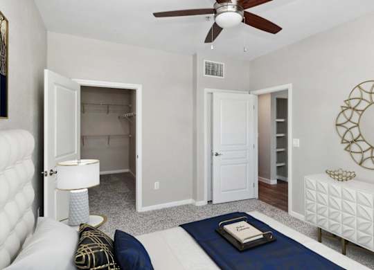 A living room with a white couch, a blue rug, and a ceiling fan.