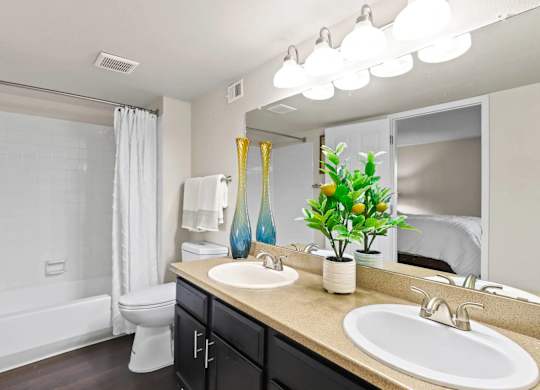 A bathroom with a white tub, sink, and mirror.