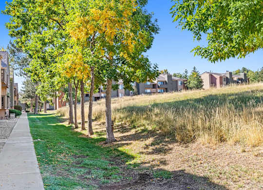 A row of houses with trees in front of them.