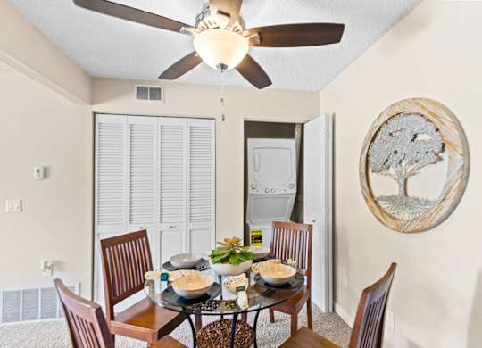 A dining room with a table set for four.